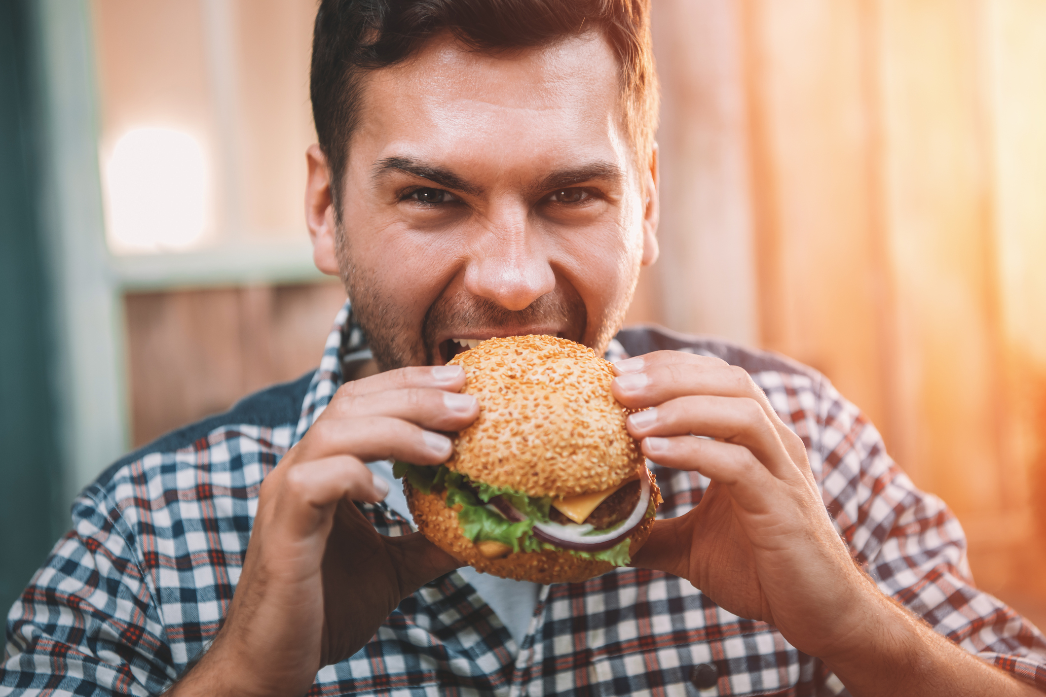 A man about to bite into a hamburger