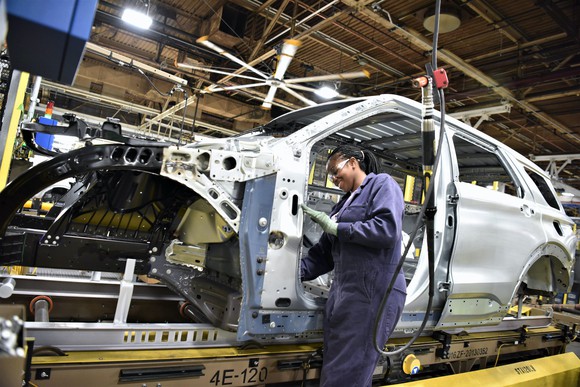 A worker attaches parts to a partially assembled 2020 Ford Explorer on a production line at Ford's Chicago Assembly Plant.