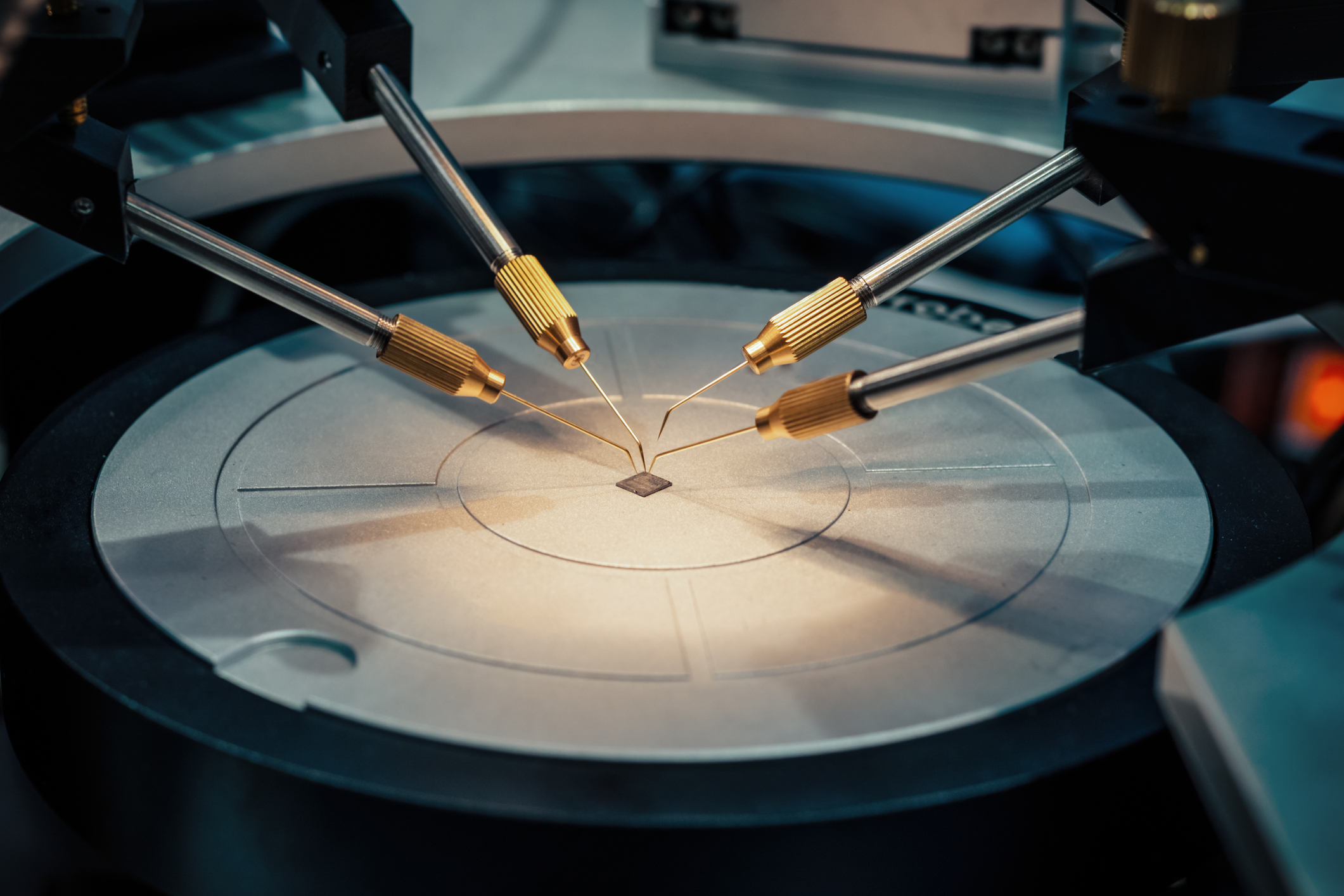 Robotic probes testing an unpackaged semiconductor.