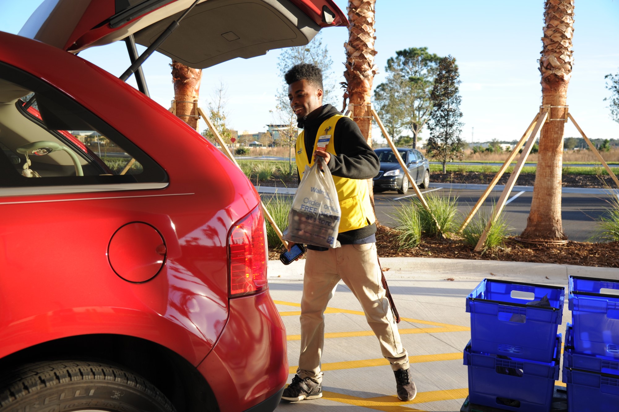 A Walmart employee loading purchases into a car