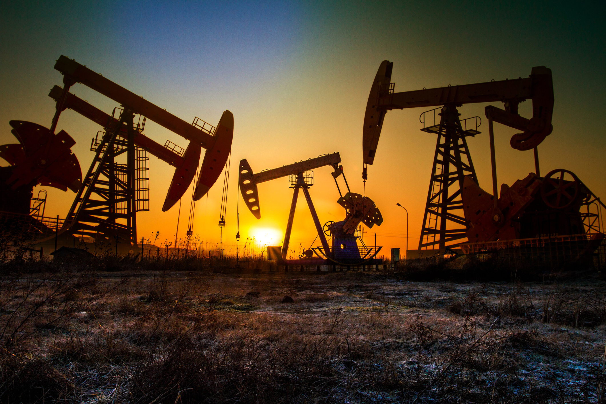 Oil pumps with the sun setting in the background.