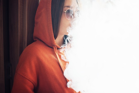 Woman partially concealed by vapor cloud