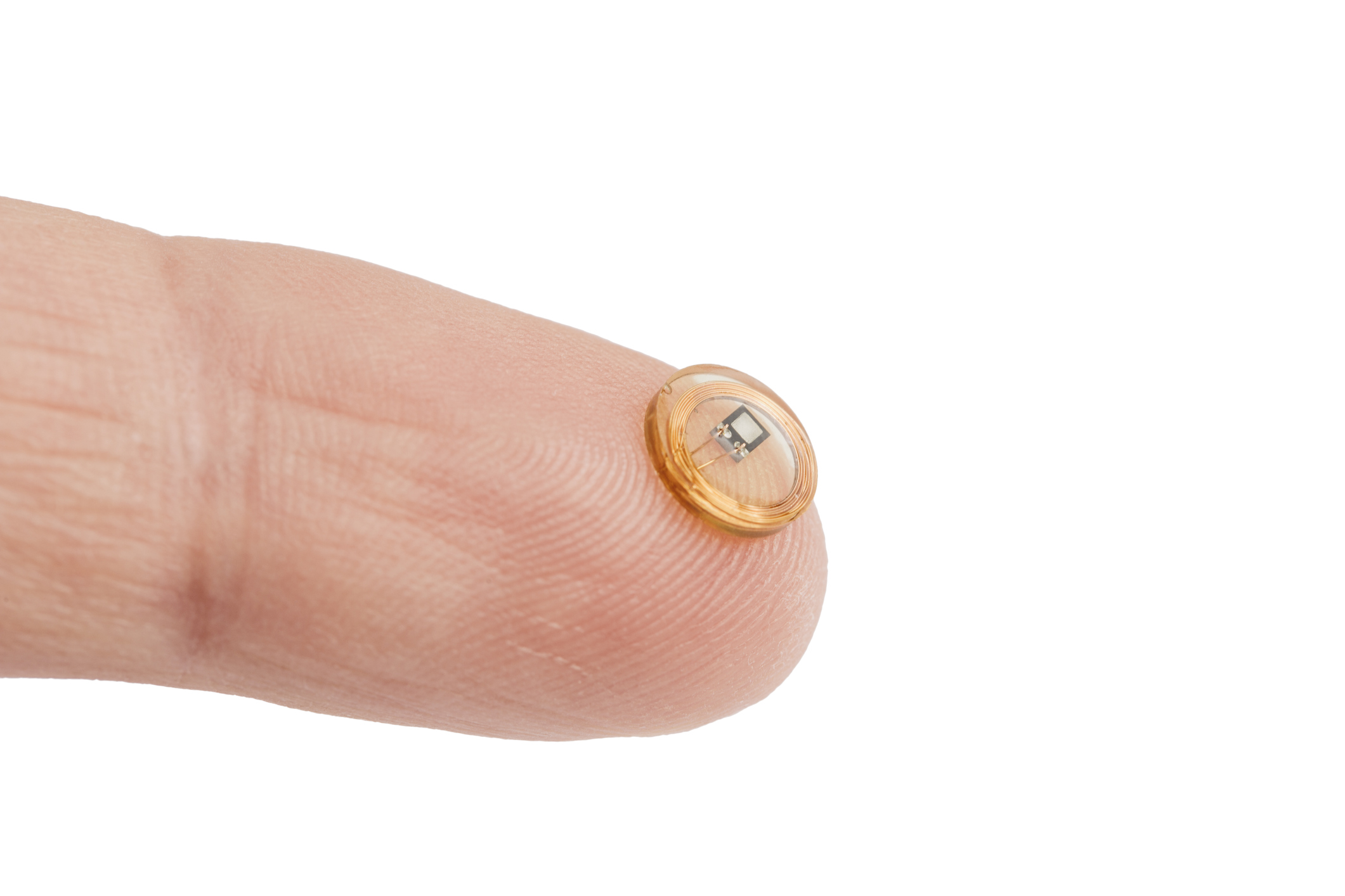 A tiny RFID chip balanced on a fingertip.