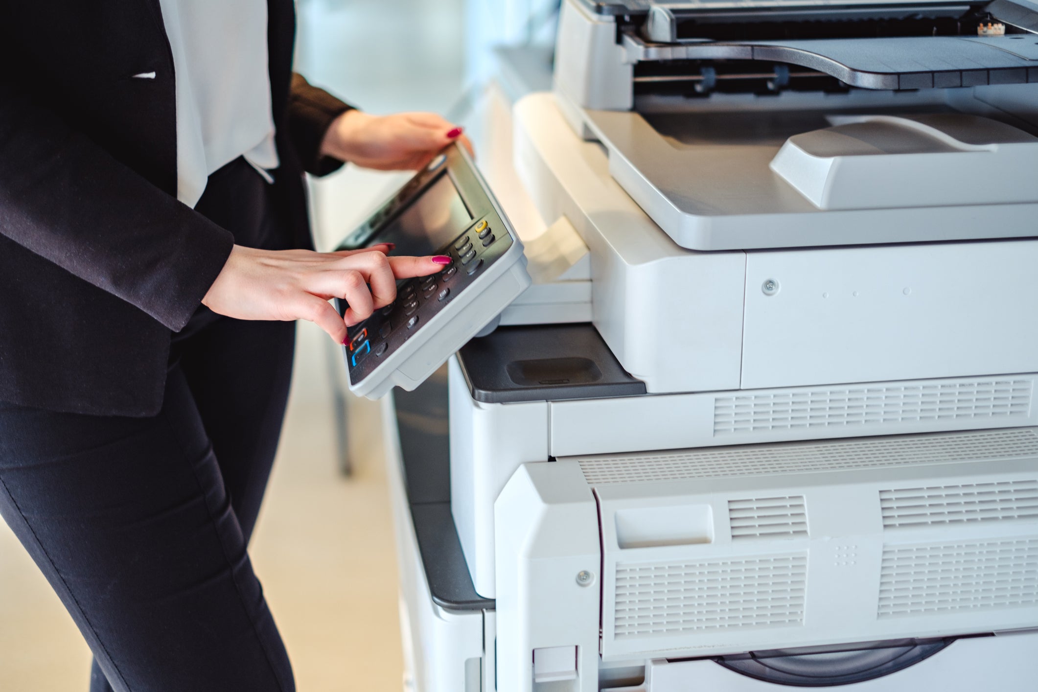 Person at copier touching the control screen.