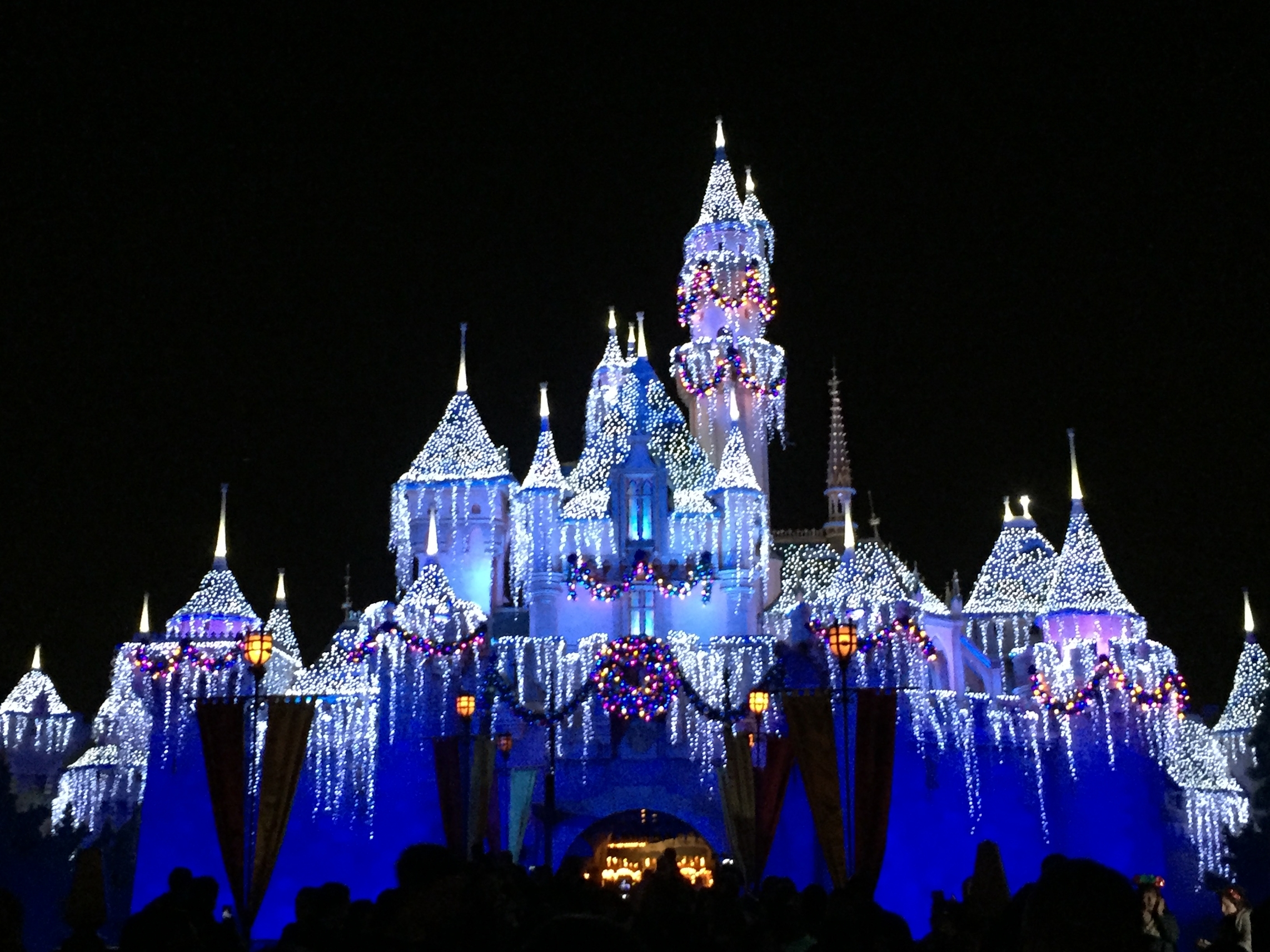 Sleeping Beauty Castle at Disneyland at night adorned for the winter.