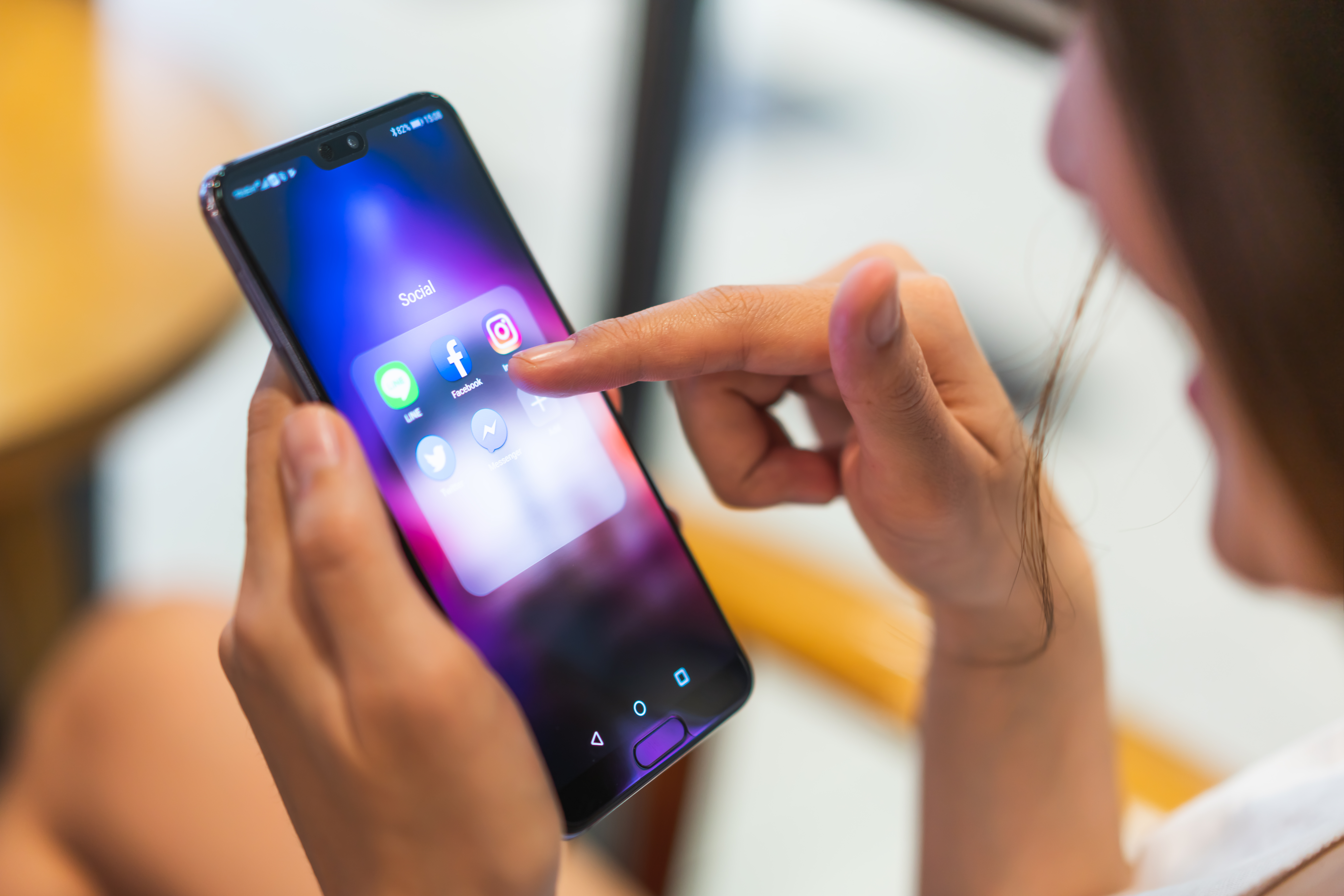 Person clicking Facebook app on her phone