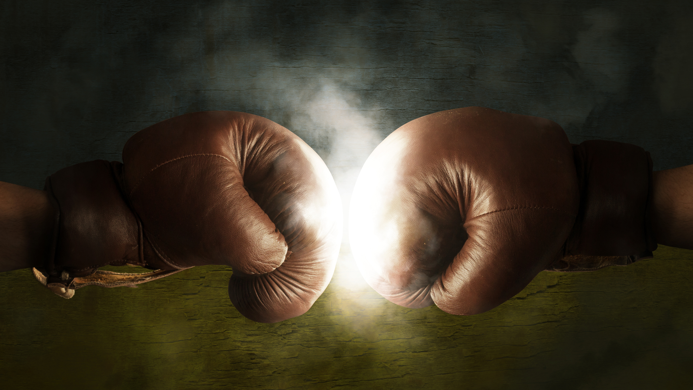 Two boxing gloves colliding.