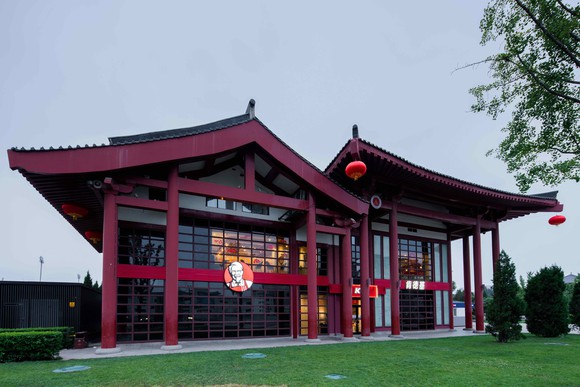 The outside of a KFC store in China, designed with a sloping Chinese architectural roof line.