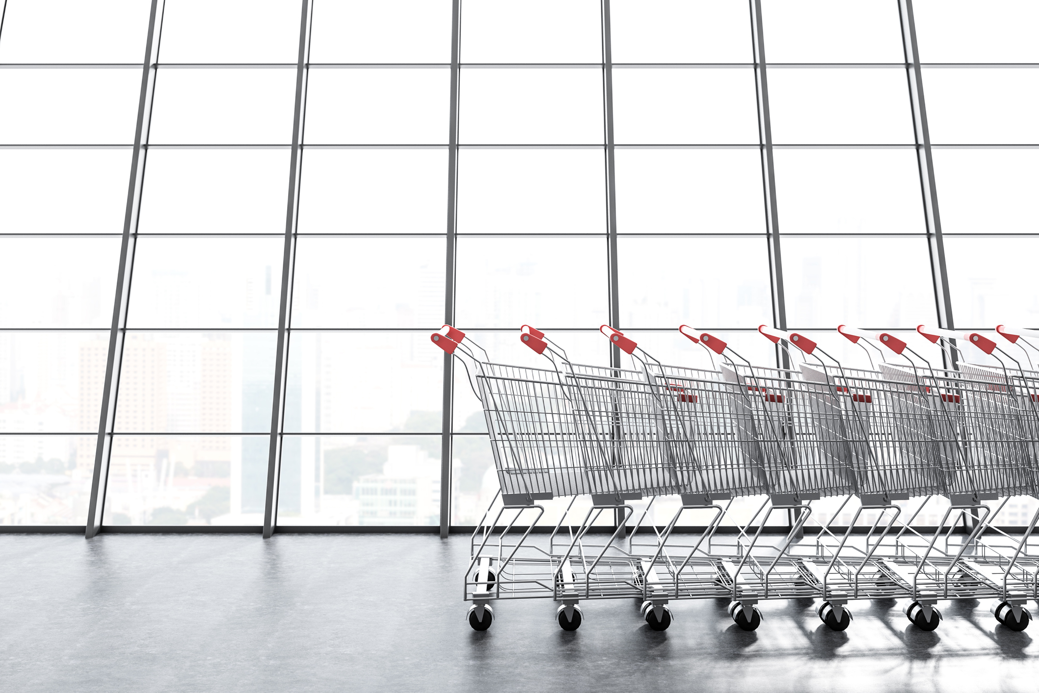 A row of shopping carts in front of a large window.