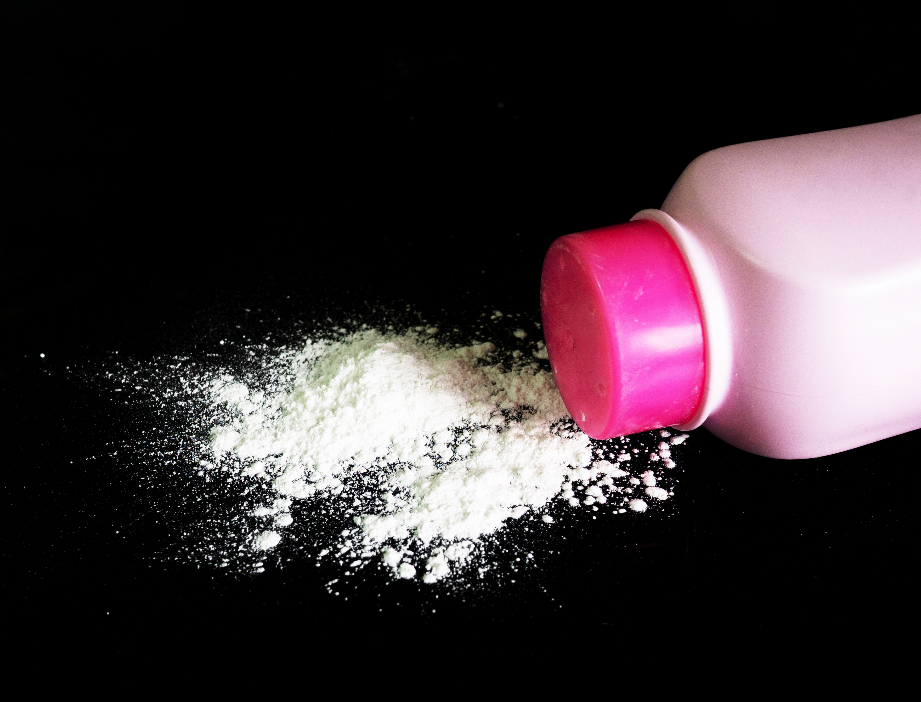 Baby powder bottle with powder spilled out.