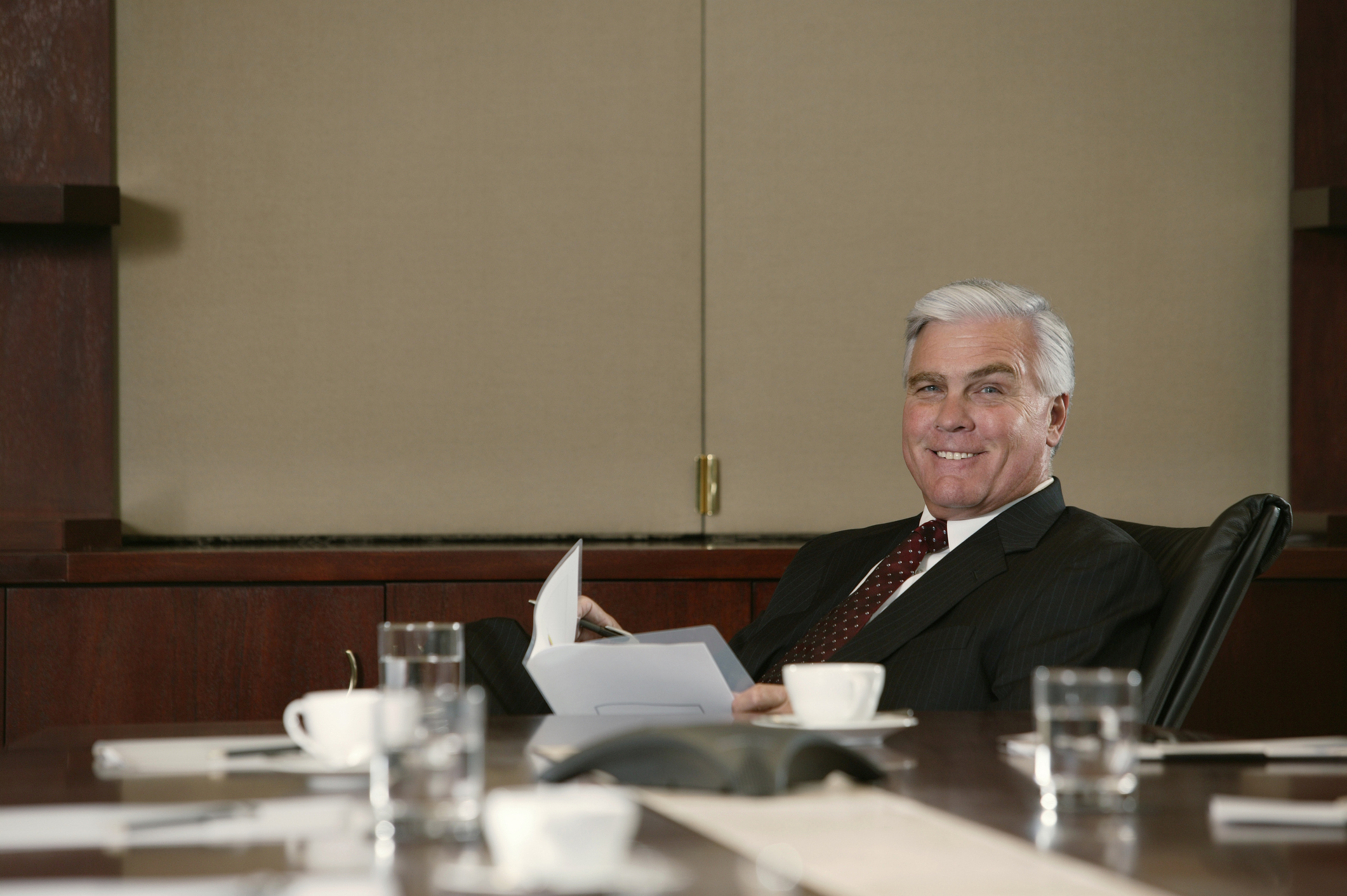 A businessman smiling from behind his desk