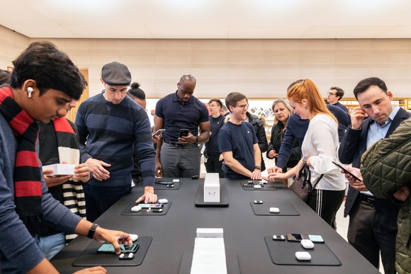 Customers at an Apple Store trying out AirPods Pro