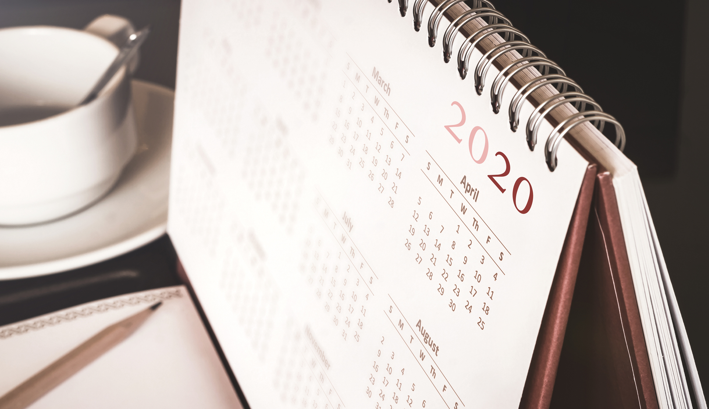 2020 calendar sitting next to notebook and mug