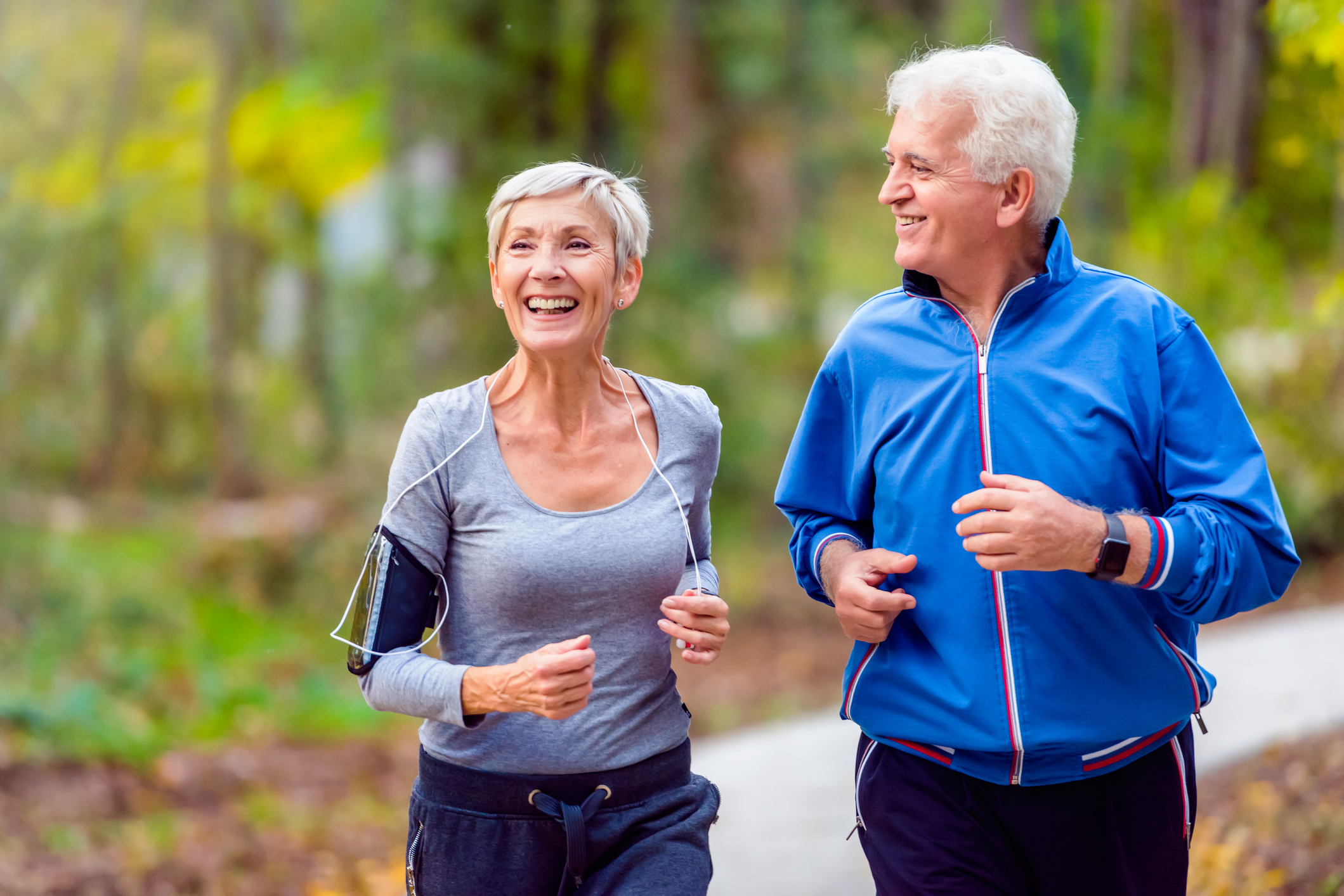 Smiling older man and woman running outdoors
