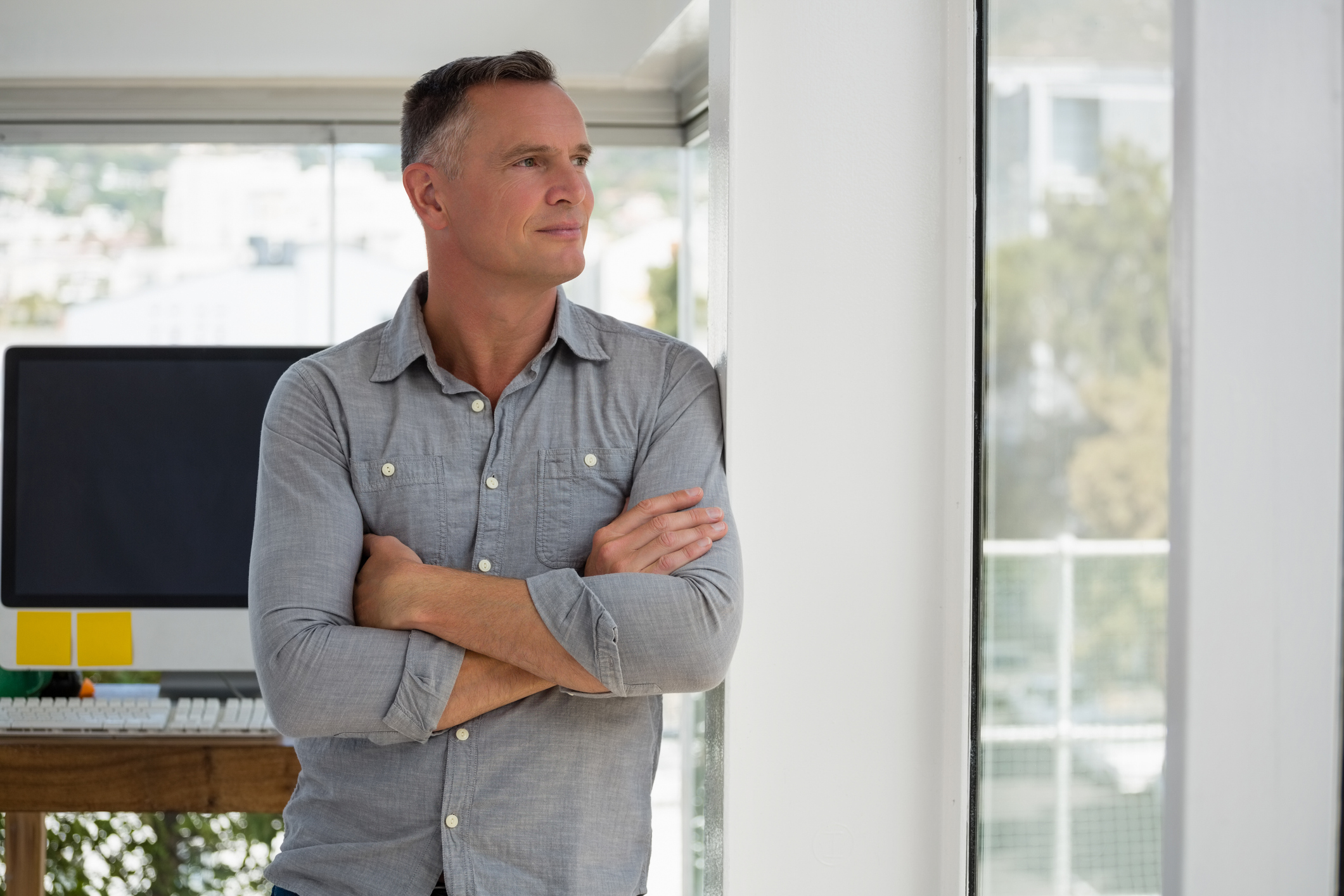 Older man at office staring out window