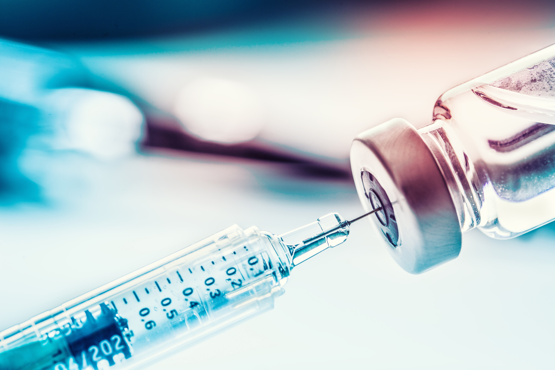 A syringe draws liquid from a vial in preparation for an injection.