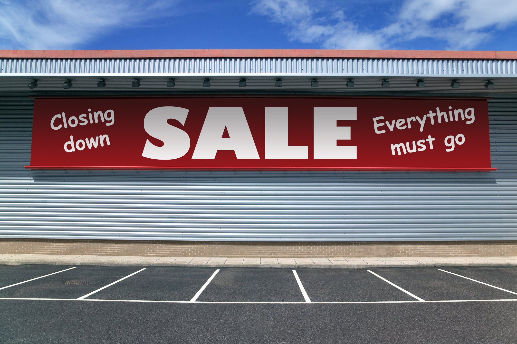 Red banner hanging outside a store, with the words Closing Down, Sales, Everything Must Go.