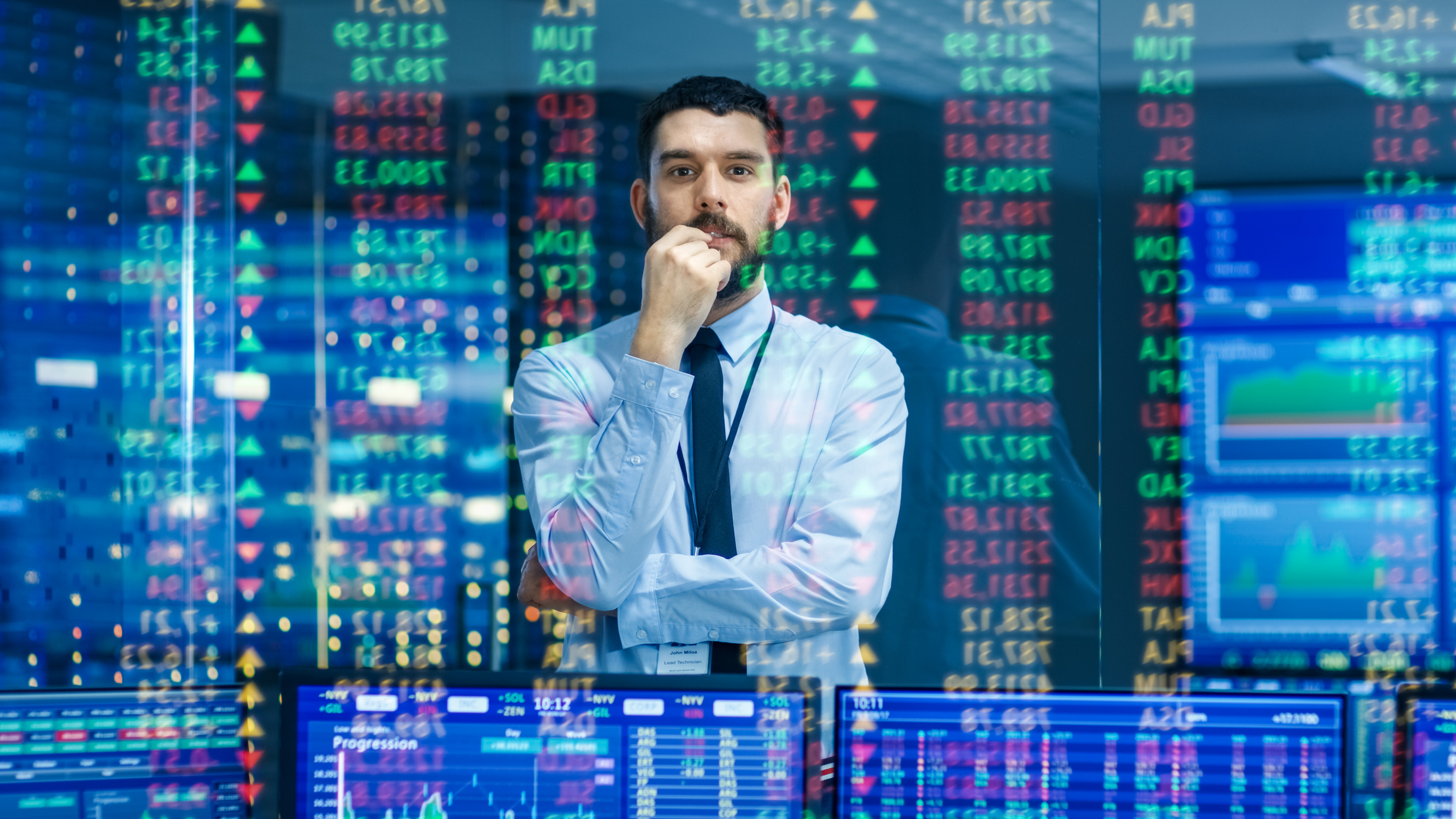 Man watches stock ticker numbers and graphs.