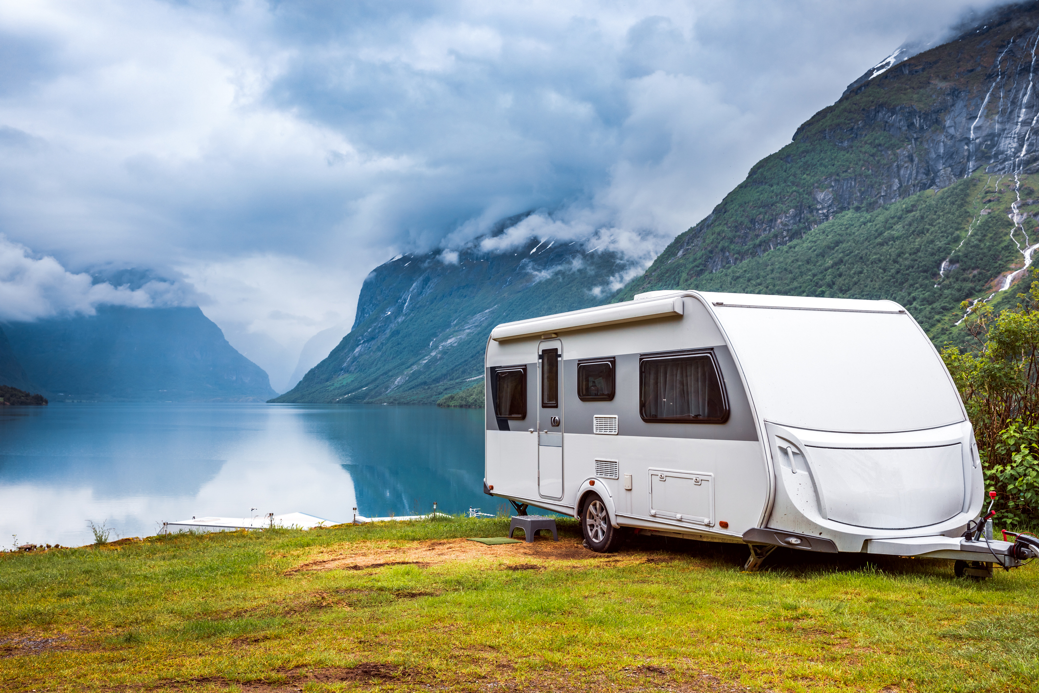 An RV parked by a mountain lake.
