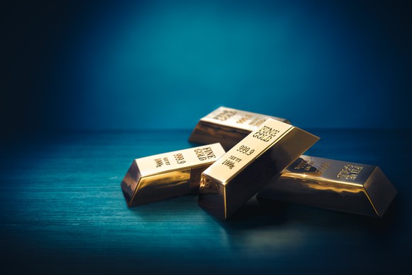 Gold bars shine amid a dark background.