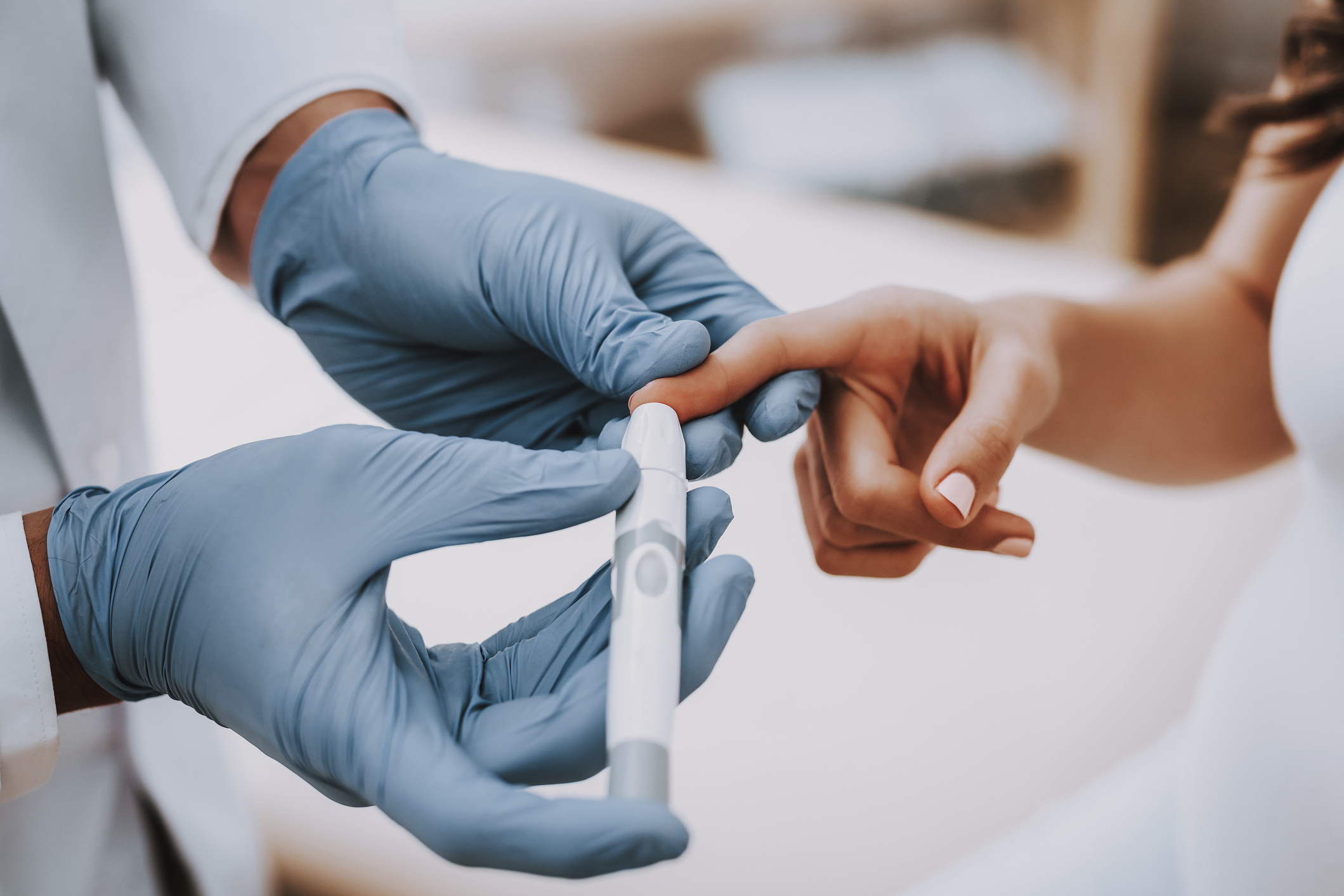 Doctor testing patient's blood sugar level.