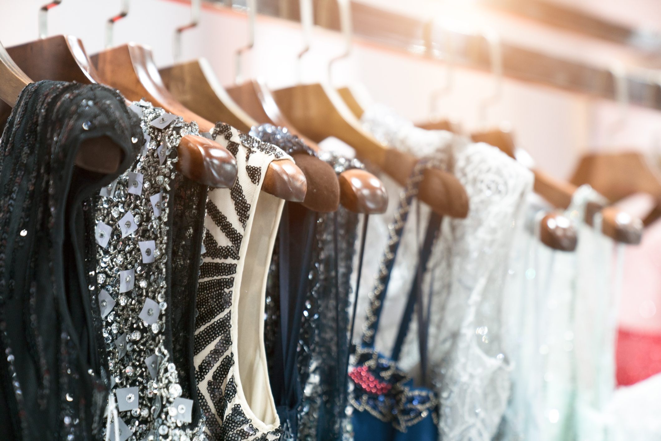 Sequined dresses, in black and white, on hangers in a store