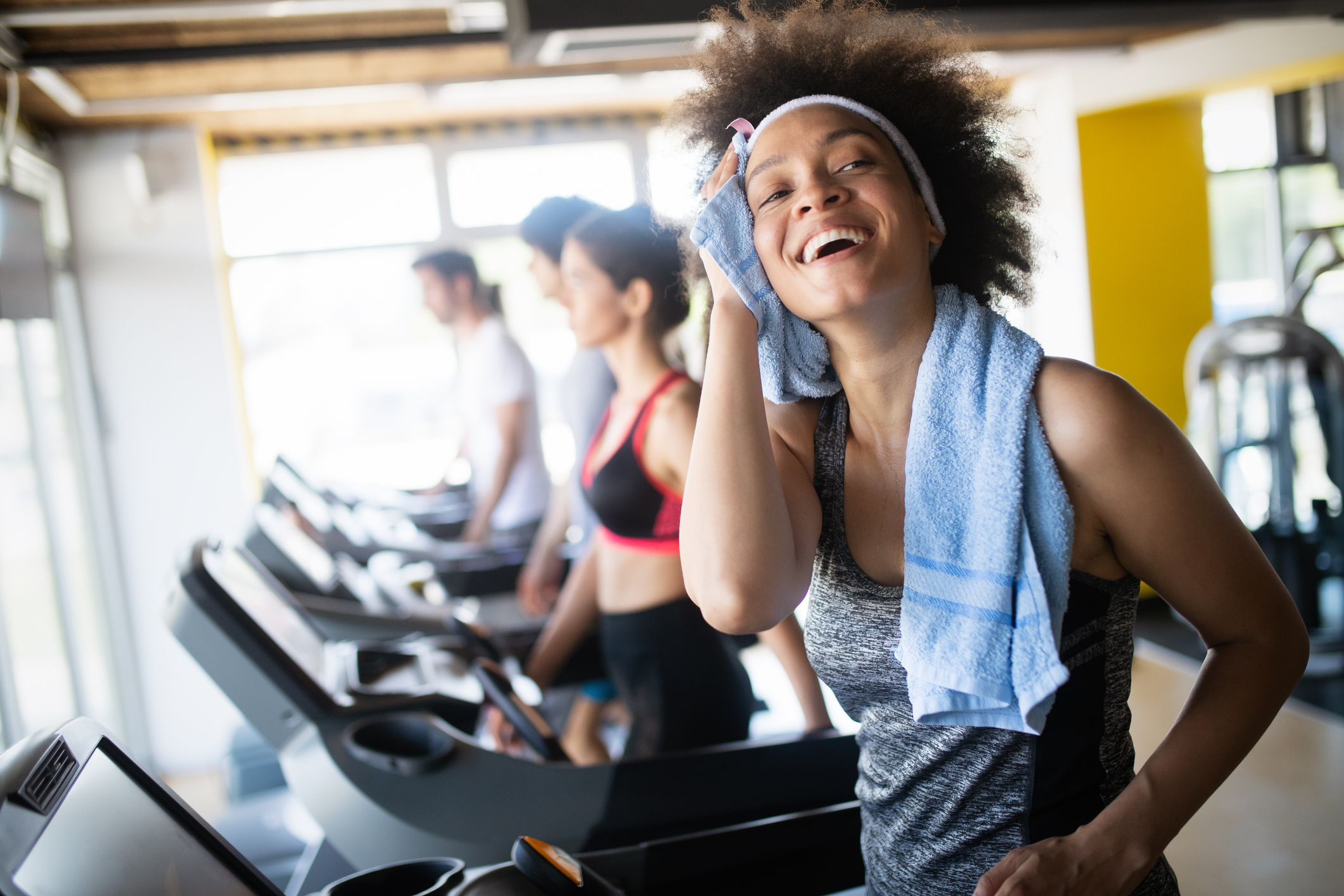 Woman on treadmill wiping herself with a towel