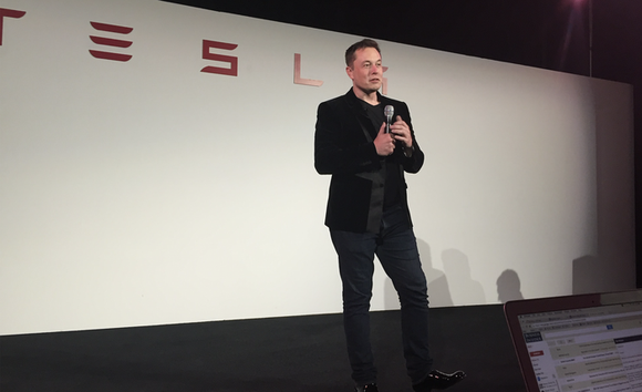 Tesla CEO Elon Musk speaking on a stage.