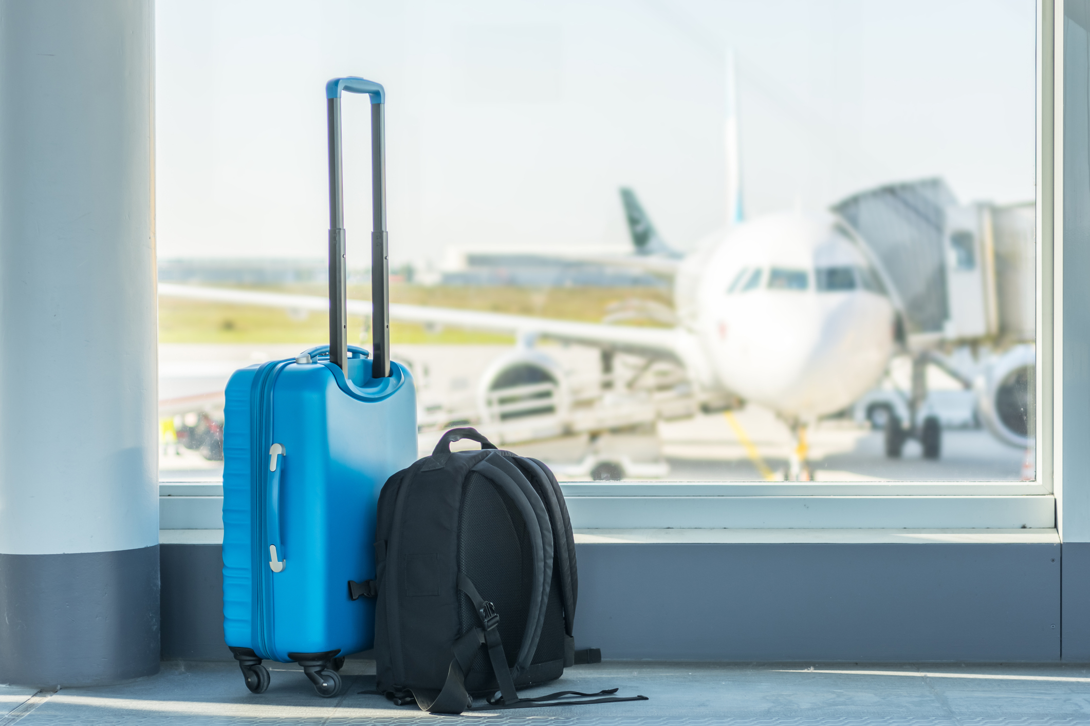 Luggage at an airport with a plane in the background.