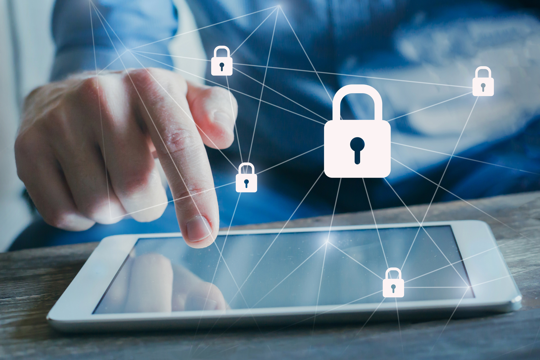 A man using a tablet with a digital cybersecurity embellishment