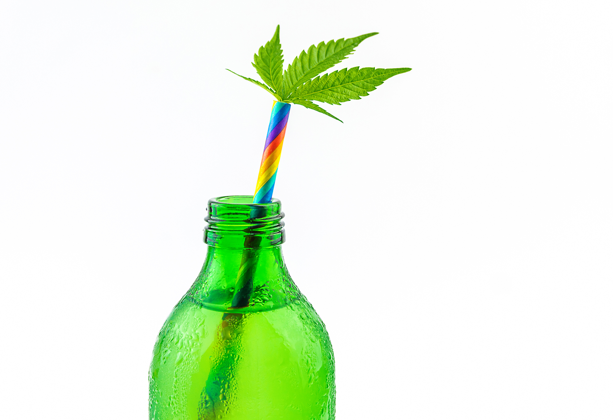 Bottle containing a liquid beverage with a multicolored straw with a cannabis leaf sticking out of the end of the straw.