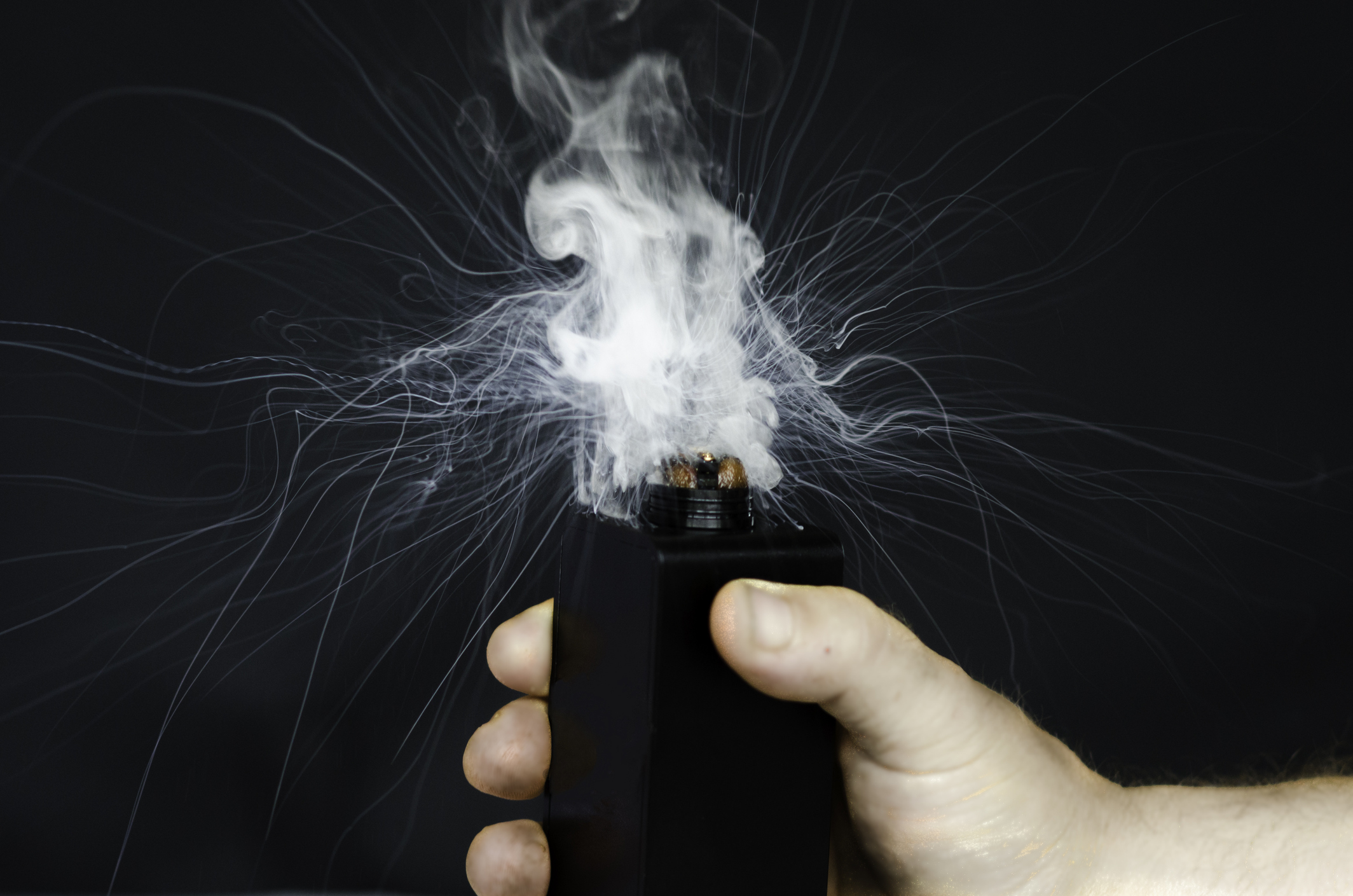 A hand activating a vaporizer.