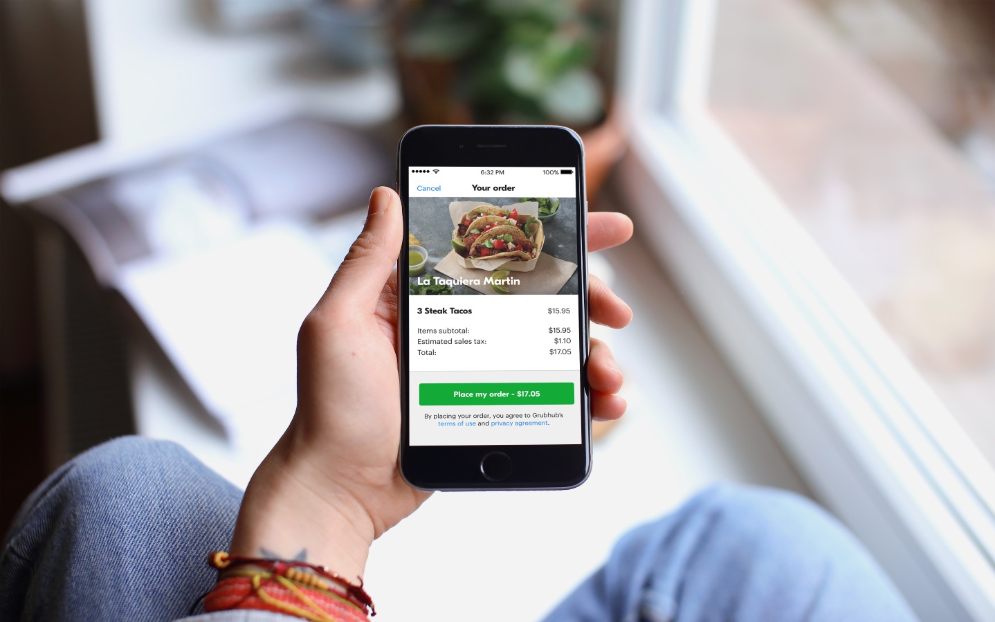 A person holding a phone with the Grubhub app open