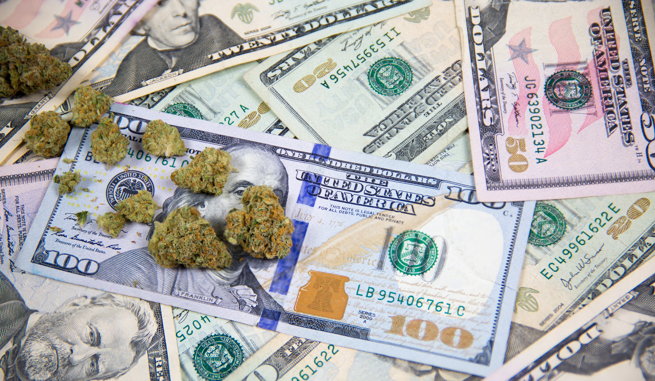 Marijuana buds atop a collection of US currency.