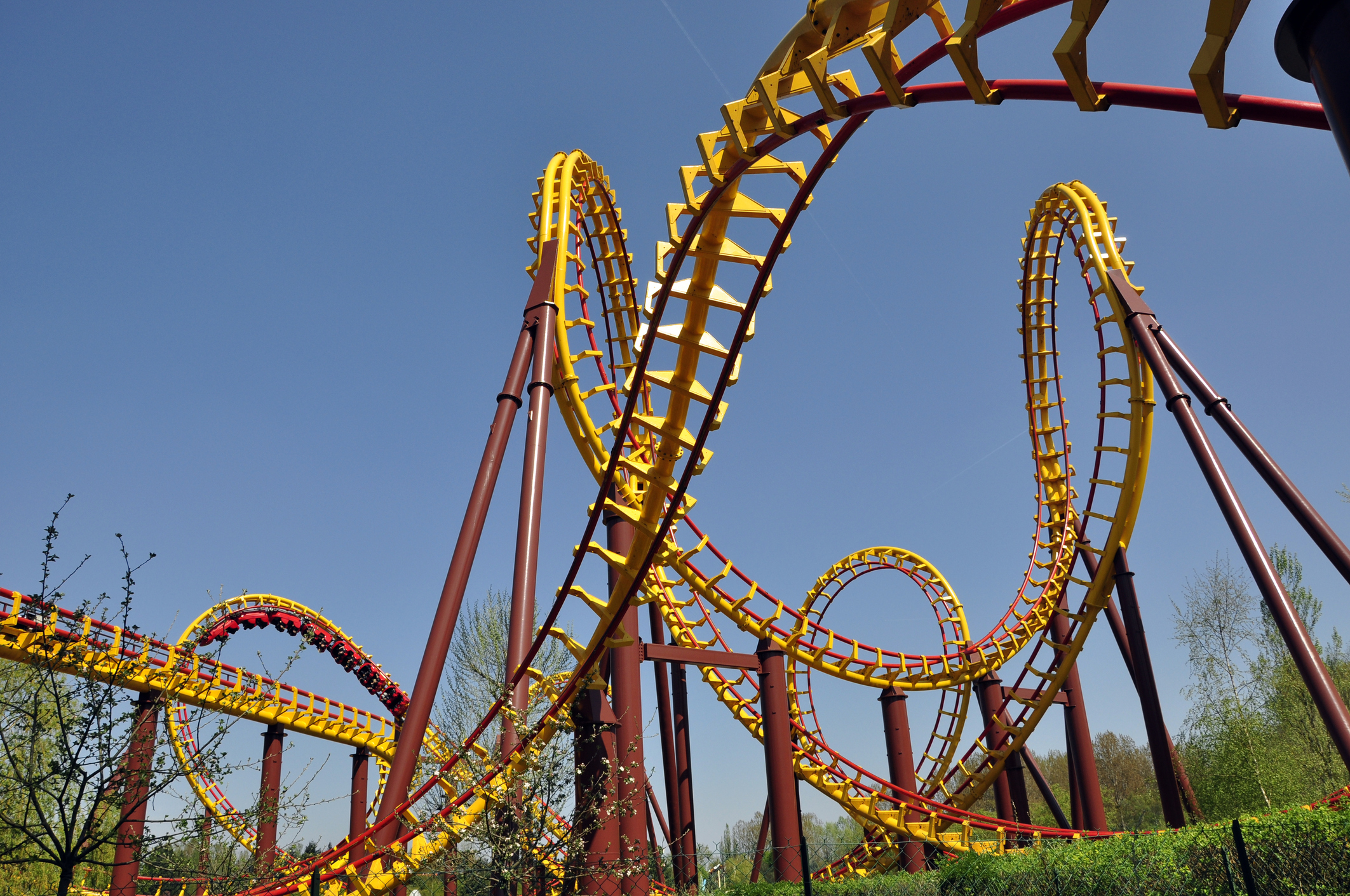 Close-up photo of a complicated roller coaster with many twists, loops, and sharp turns.