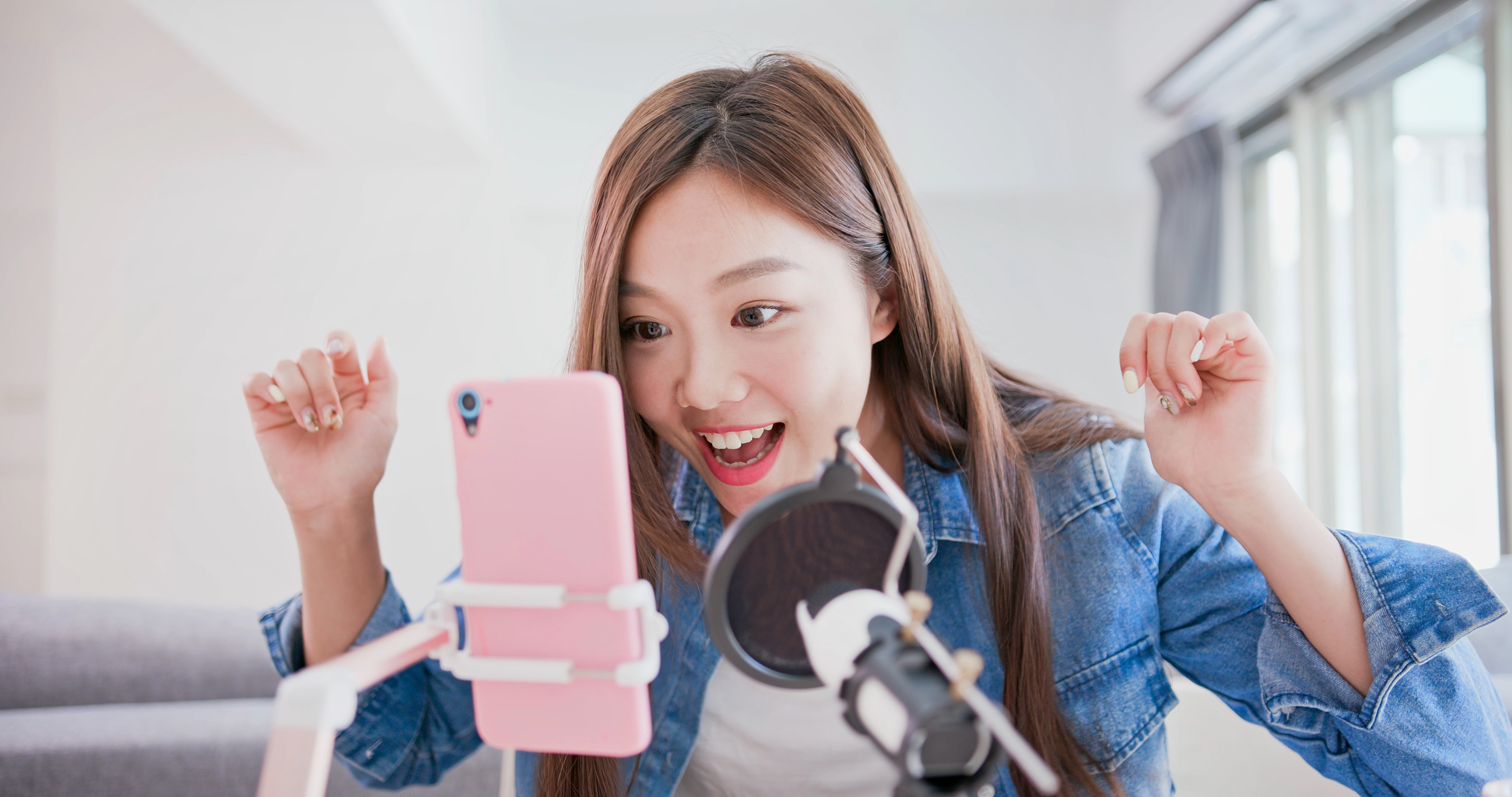 A young woman streams a live video on her smartphone.