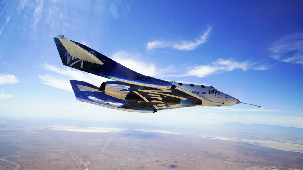 Virgin Galactic spacecraft flying over a desert.