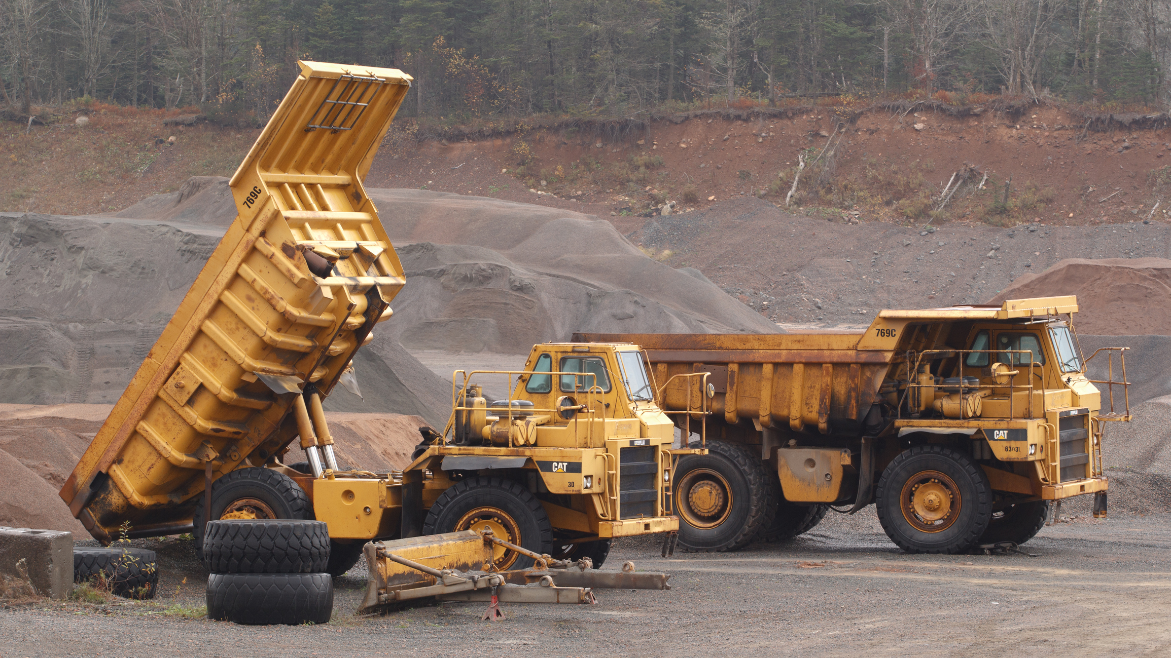 Two off-highway Caterpillar trucks.