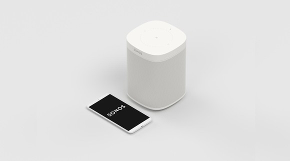 A white Sonos wireless speaker next to a smartphone firing up the Sonos app.