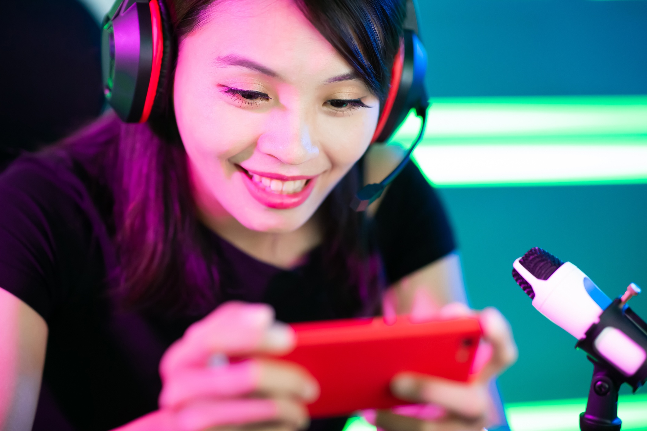 Teen girl wearing headphones and looking at her smartphone