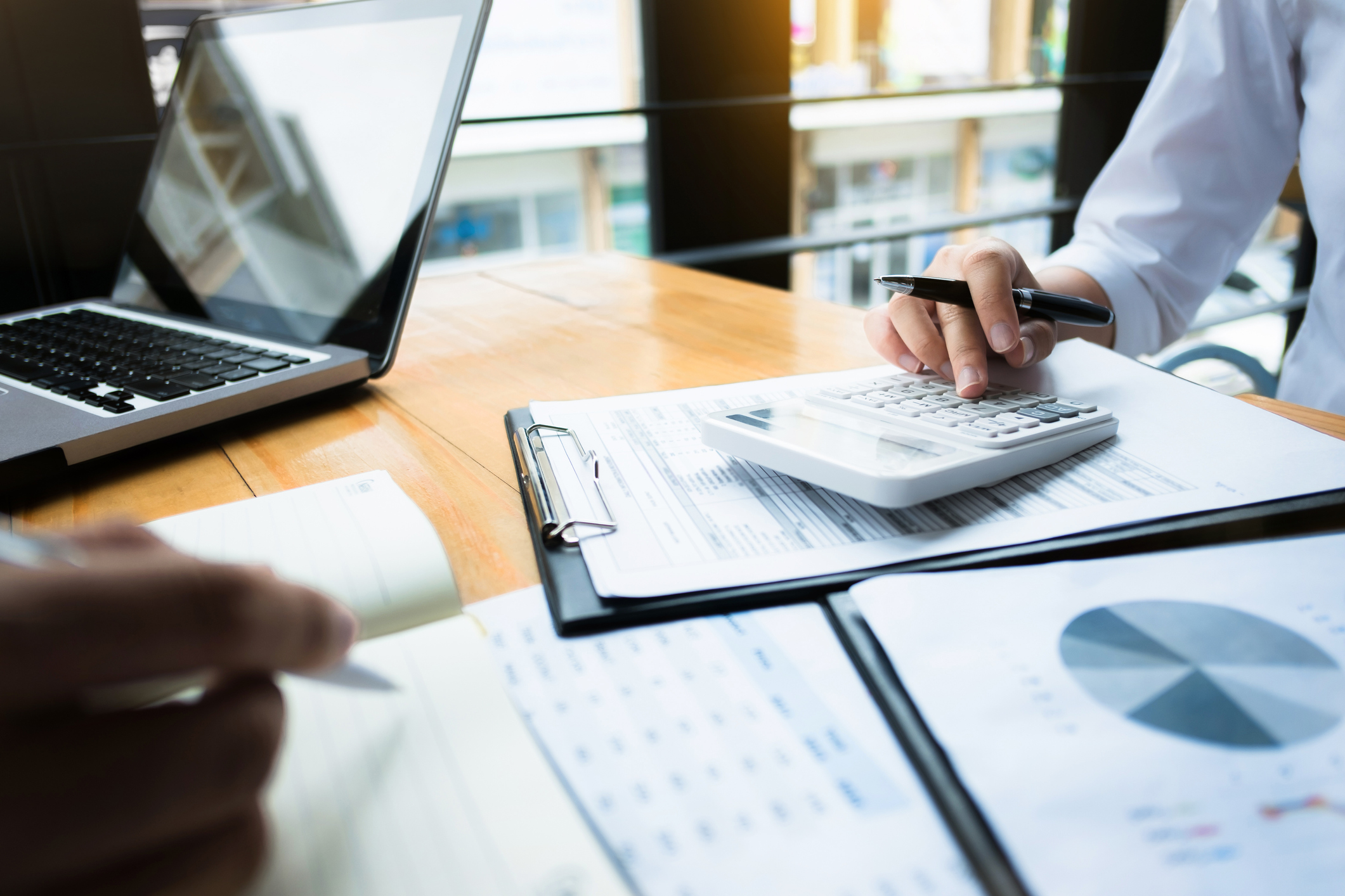 A man working with a calculator and documents in an office