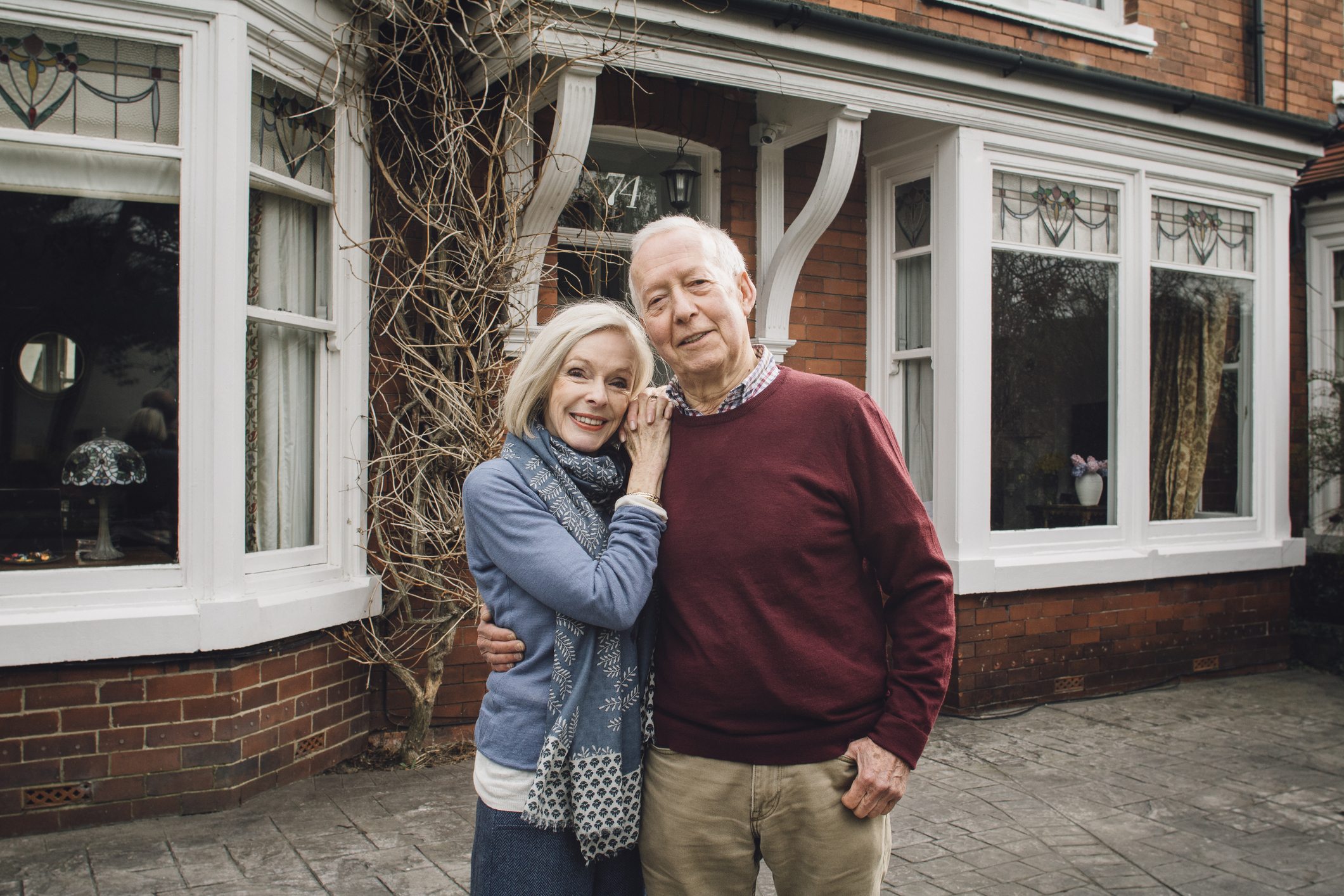 Senior man and woman standing in front of a house