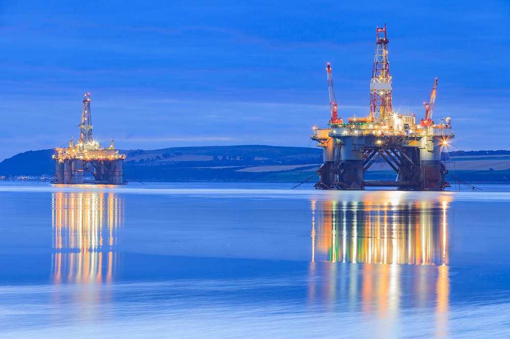 Offshore drilling rigs at night.