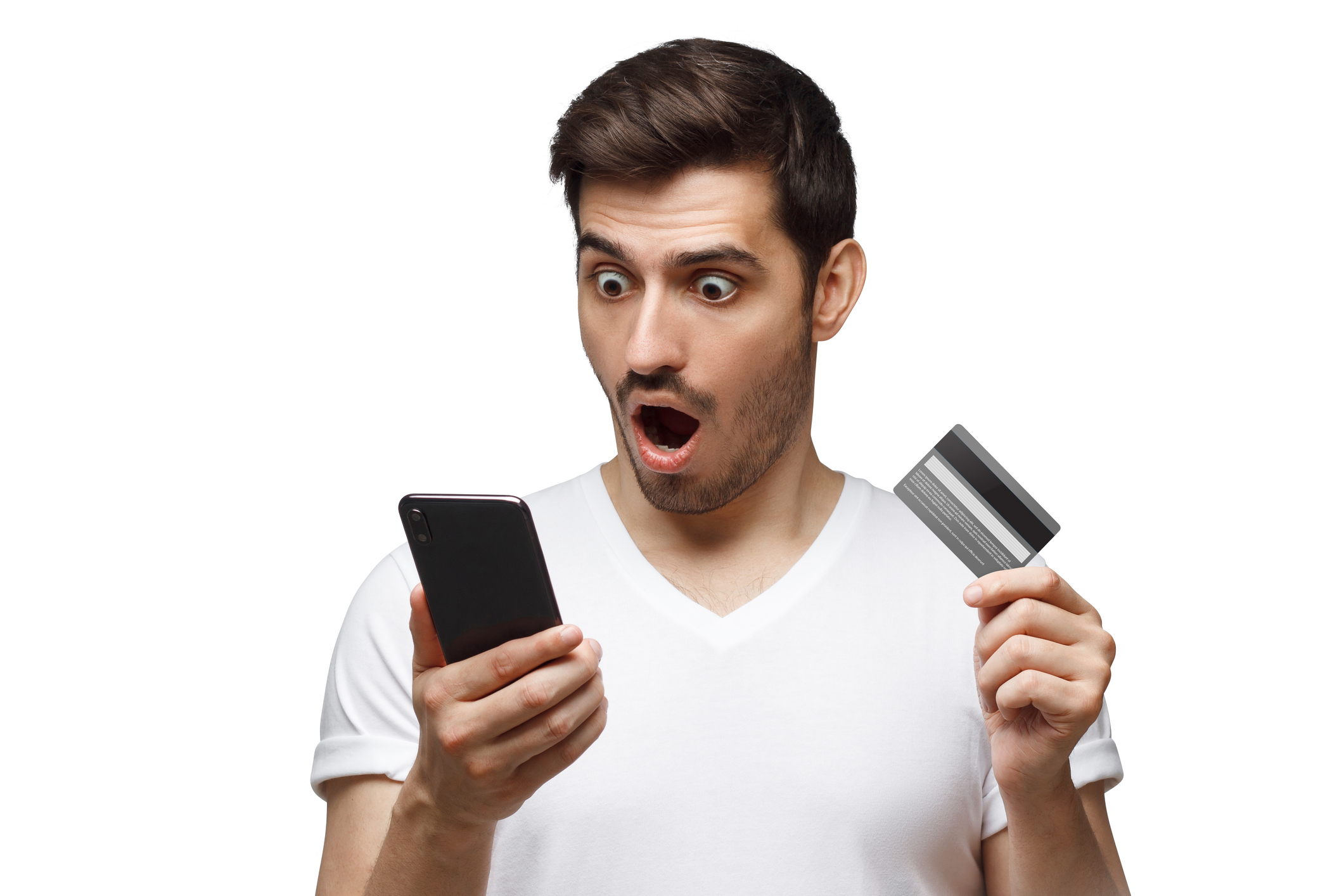 Man with surprised expression holds credit card and looks at phone