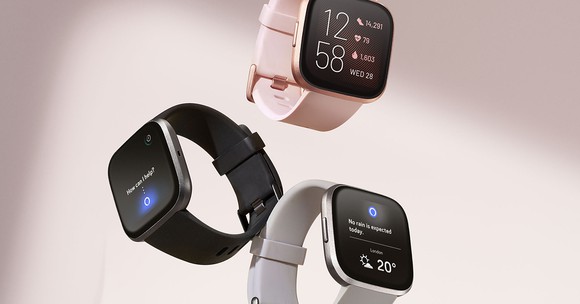 Three Fitbit Versa smartwatches, one each displayed in black, pink, and silver.