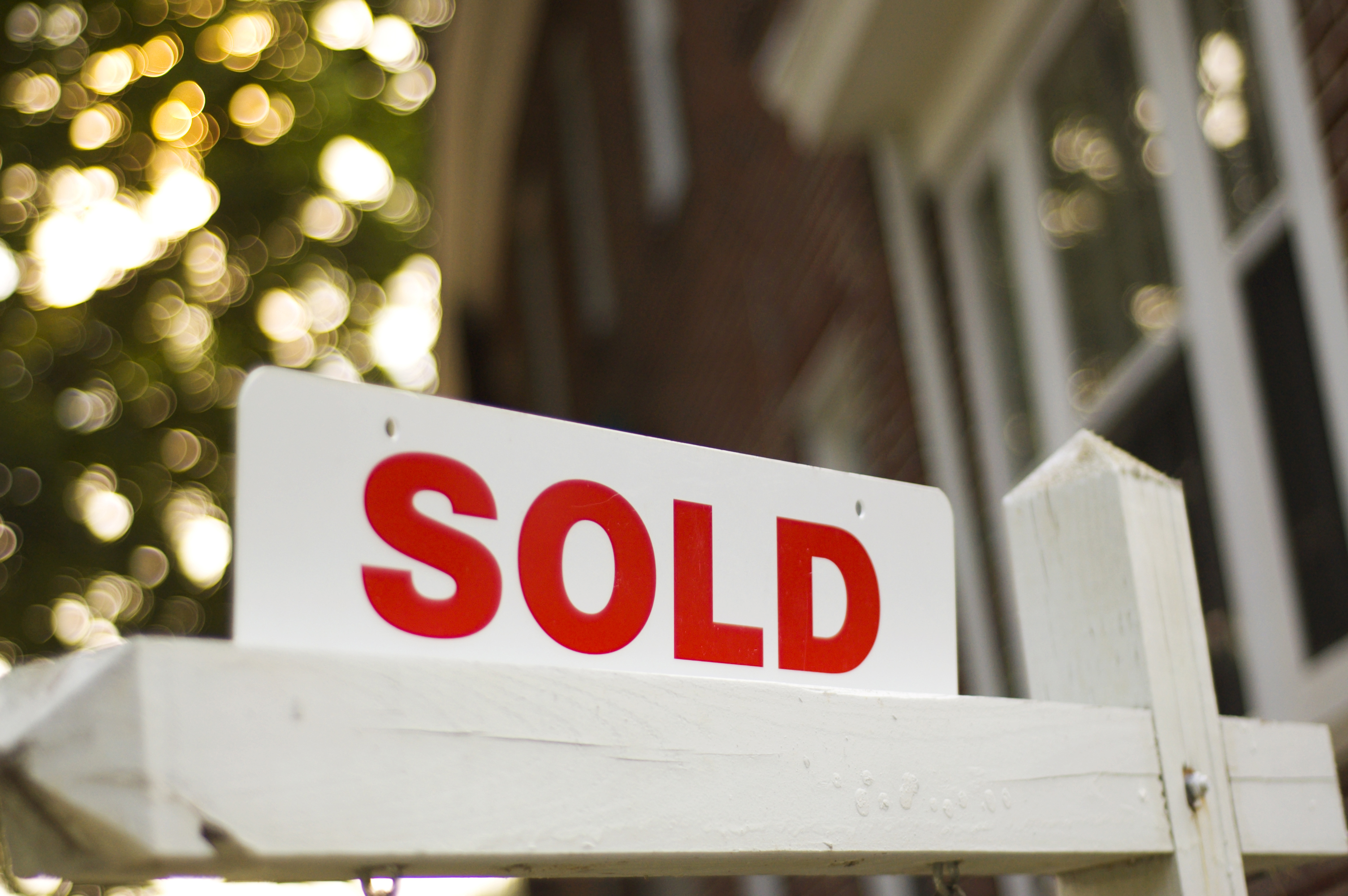 A sign labeled sold on a sign post