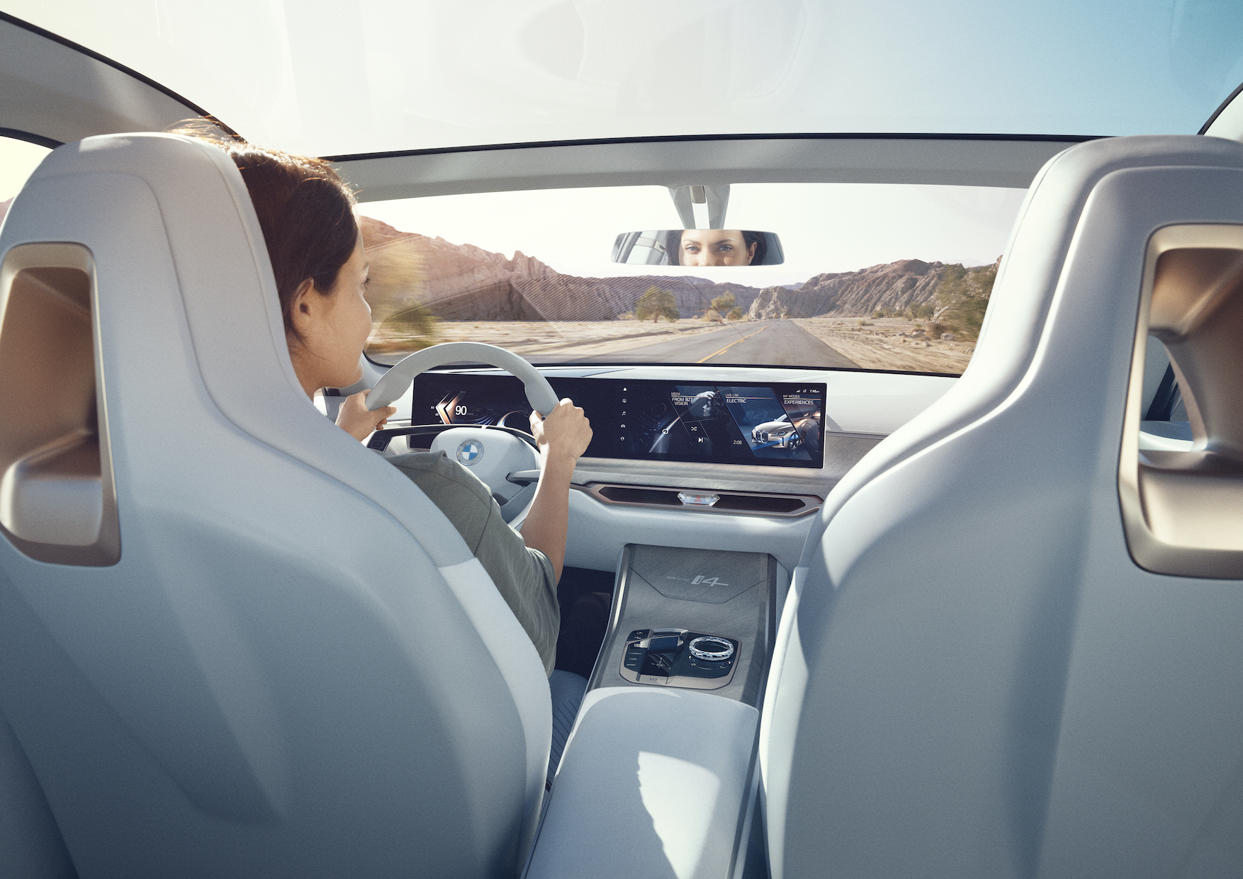 A view of the Concept i4's interior from the back seat, showing the curved glass dashboard and large sunroof.