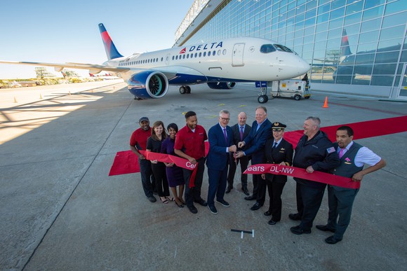 Delta execs at a ribbon cutting in front of a new aircraft.