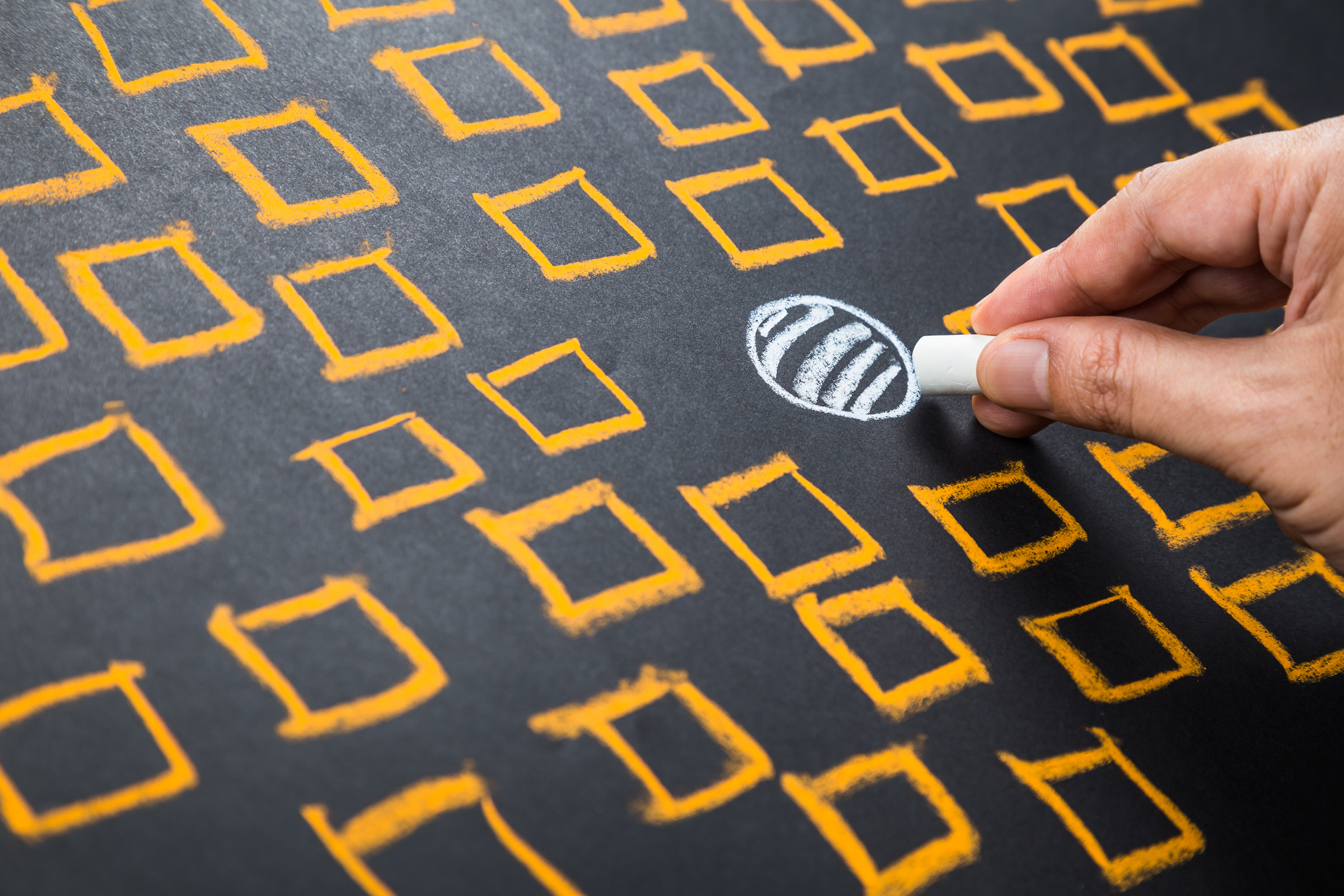 Hand drawing one unique "niche" symbol on a chalkboard