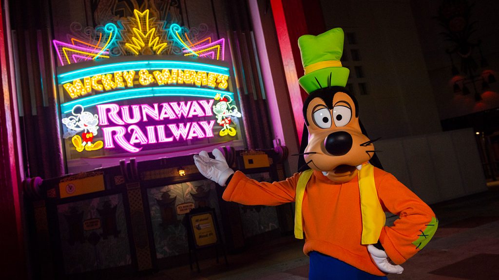 Goofy in front of the illuminated Micky & Minnie's Runaway Railway marquee.